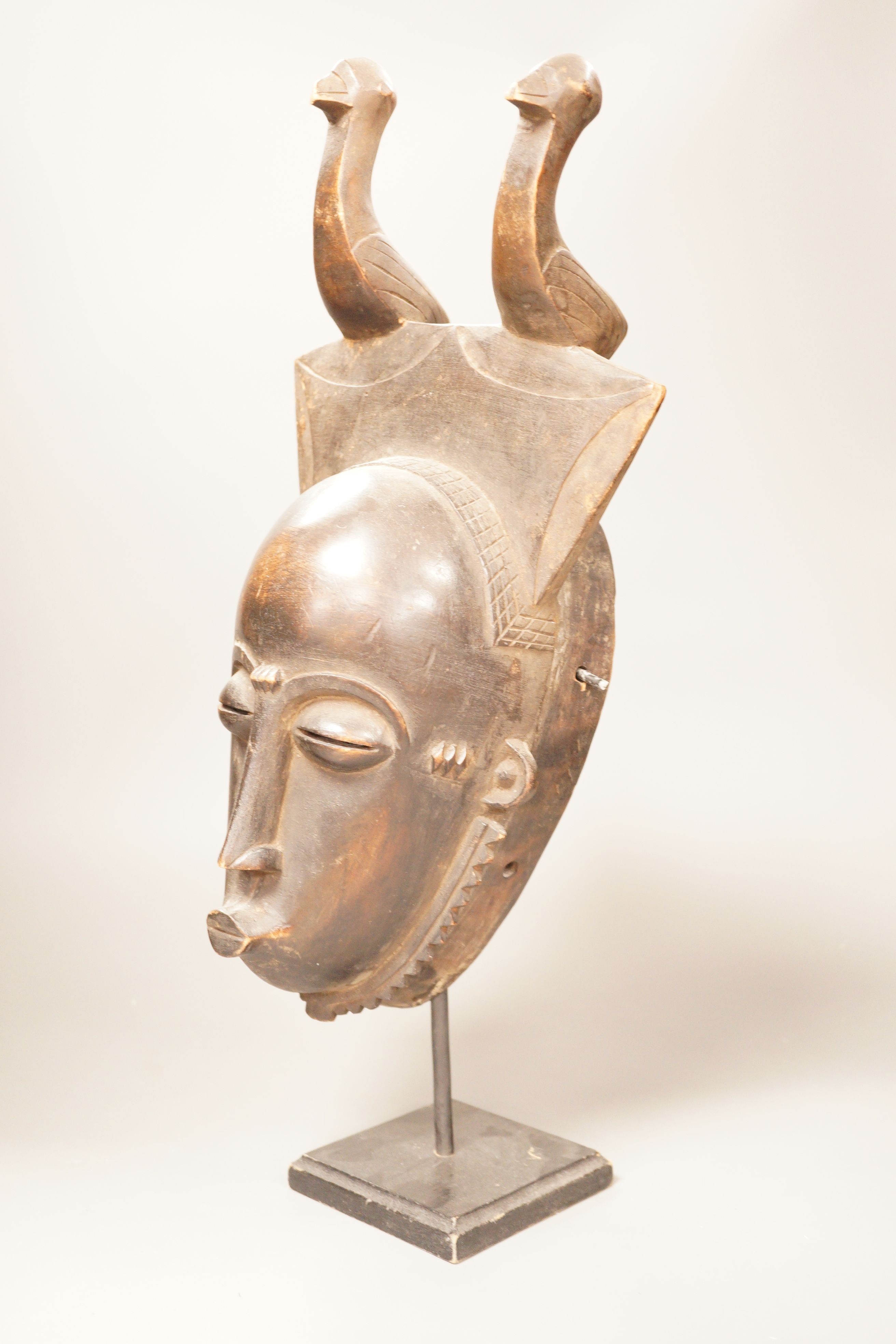 A West African tribal mask, possibly Baule, on stand, 47cm total